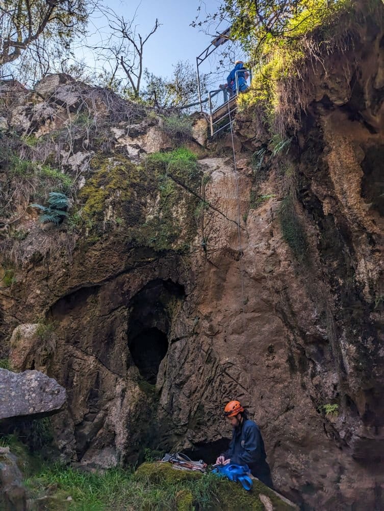 Abseiling down into cave
